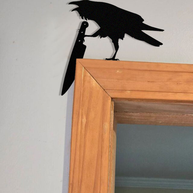 Raven holding a knife metal art