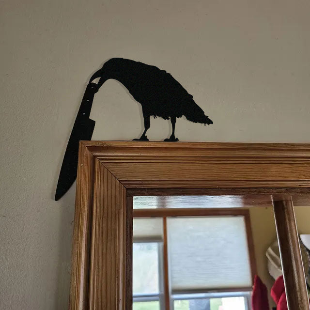 Raven holding a knife metal art