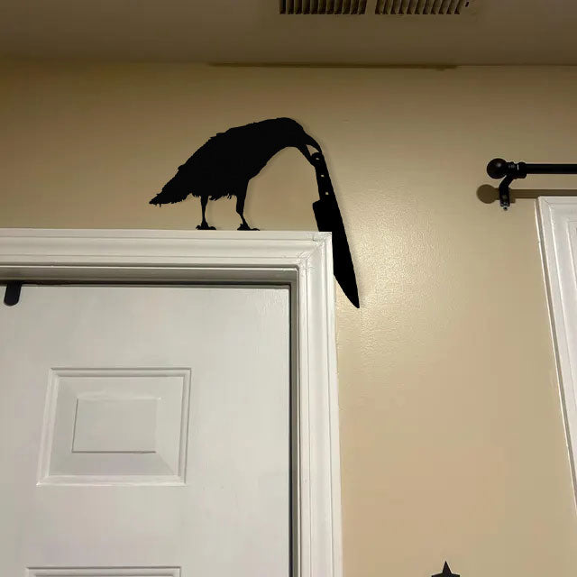 Raven holding a knife metal art