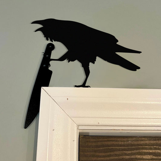 Raven holding a knife metal art