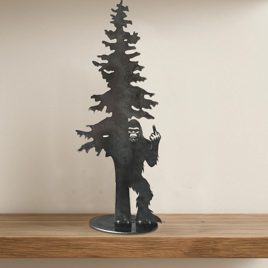 Bigfoot hiding behind an evergreen tree with his middle finger raised